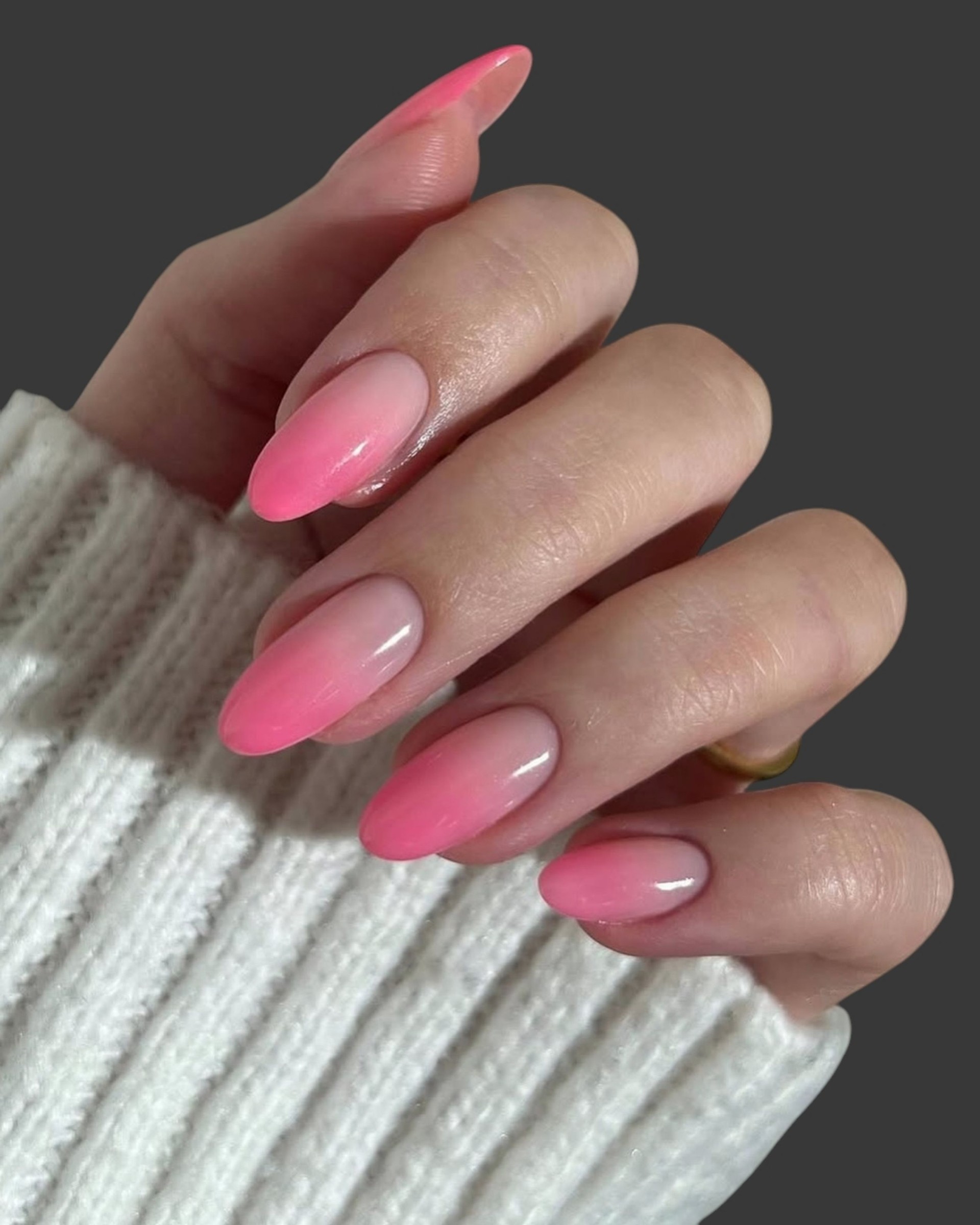 Young woman's hands with trendy and modern pink creative nail manicure with different trendy shapes and designs with light background